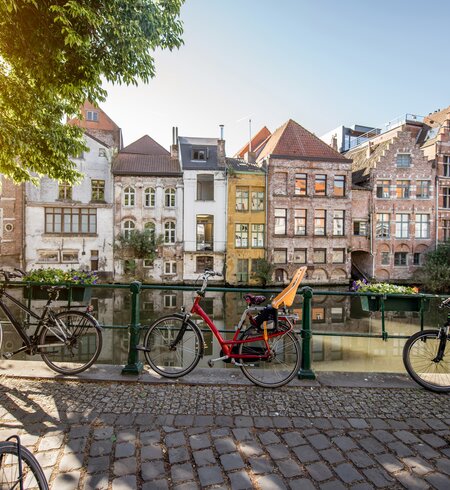 Blick auf eine Gracht mit wunderschoenen historischen Gebaeuden und Fahrraedern in sommerlichem Morgenlicht in Gent, Flandern, Belgien | © Gettyimages.com/RossHelen
