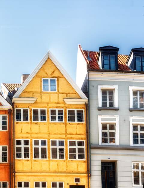 Frontale Ansicht Kopenhagener Nyahavn - Bunte traditionelle daenische Haeuser mit hellblauem Himmel | © GettyImage.com/atosan