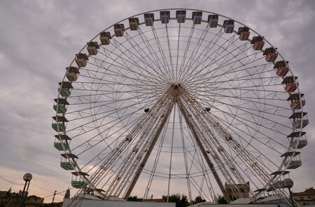 Untersicht auf das Riesenrad in Avignon mit bewoelktem Himmel | © Gettyimages.com/underworld111