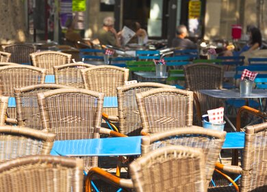 Strassenrestaurant mit vielen Stuehlen unter der Sonne im Sommer in Avignon | © Gettyimages.com/Brzozowska