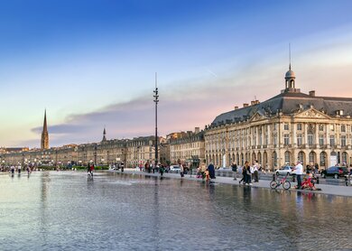 Blick auf einen Platz voller Menschen bei Sonnenuntergang in Bordeaux | © Gettyimages.com/Borisb17