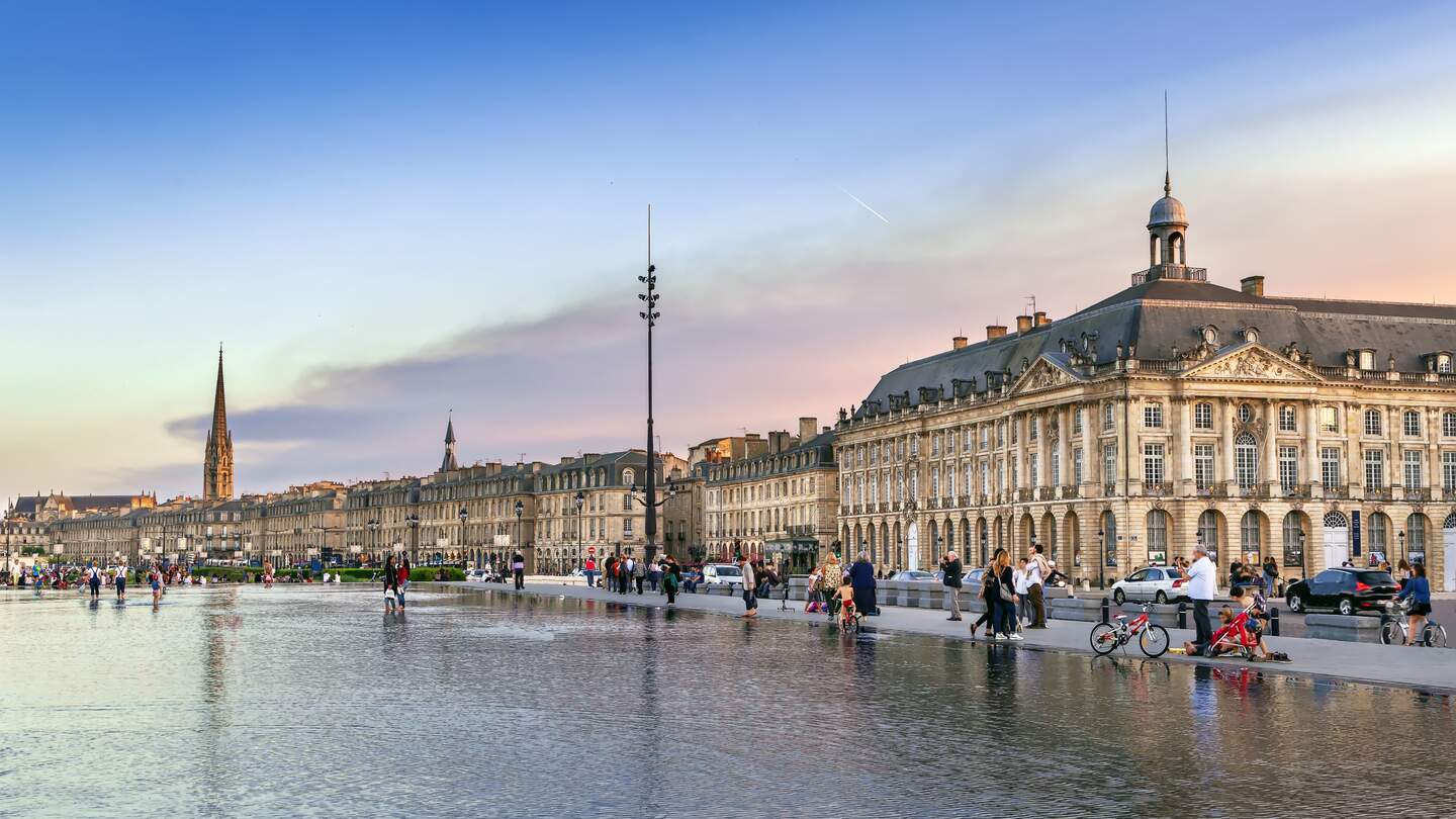 Blick auf einen Platz voller Menschen bei Sonnenuntergang in Bordeaux | © Gettyimages.com/Borisb17