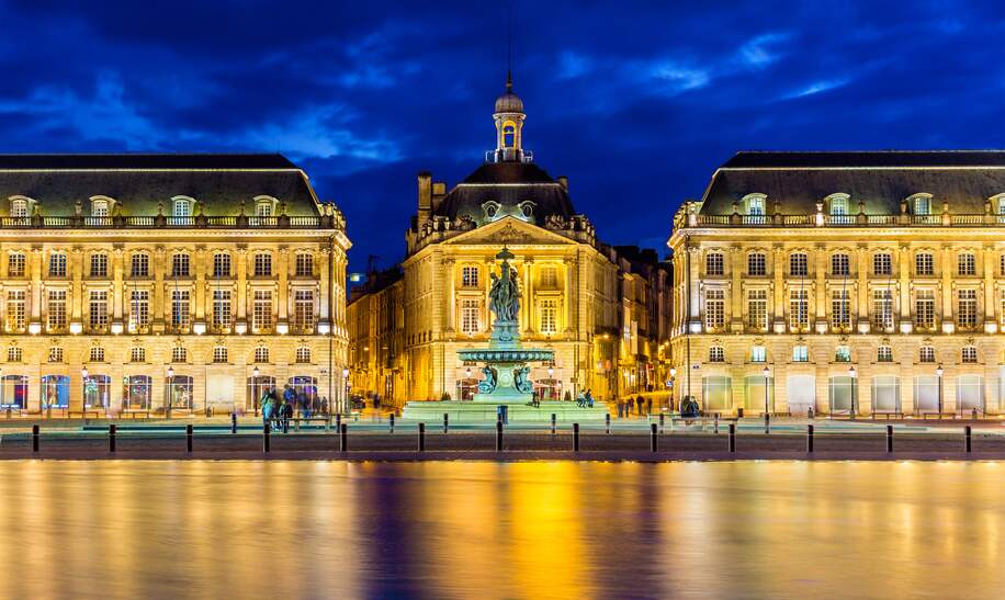 Beleuchtete Place de la bourse an der Garonne in der Nacht | © Gettyimages.com/Leonid Andronov