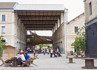 Menschen, die zwischen Street-Art-Installationen aus recyceltem Material im Espace Darwin in Bordeaux sitzen. | © GettyImages.com/martinedoucet