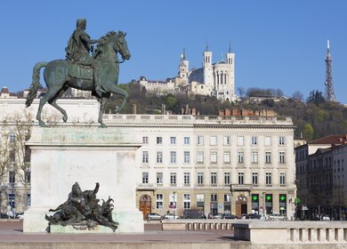 Blick auf das Reiterstandbild Ludwigs XIV. am Place Bellecour mit Basilika im Hintergrund | © Gettyimages.com/vwalakte