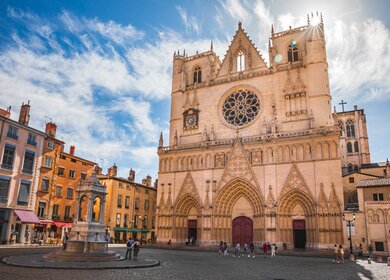 Ein franzoesischer Stadtplatz mit majestaetischer Saint-Jean-Baptiste Kathedrale in der Altstadt von Lyon mit einer Touristenmenge | © Gettyimages.com/Gregory_DUBUS