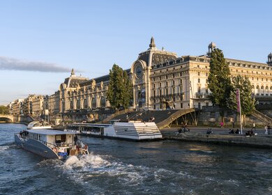 Musée d'Orsay an der Seine in Paris, ein Boot fahrend im Vordergrund auf der Seine | © Gettyimages.com/omersukrugoksu