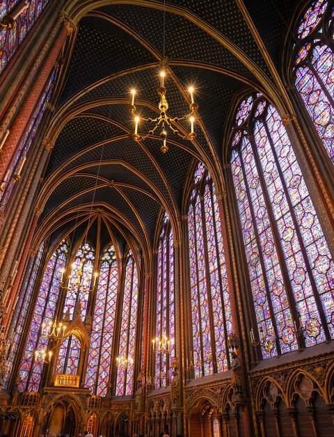 Innenraum der Kirche Sainte-Chapelle mit sehr hohen bunten Glasfenstern, eingebettet in gotische Spitzboegen. | © Gettyimages.com/neirfy