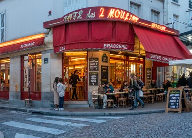 Weit davon entfernt, eine Touristenfalle zu sein, bleibt das Café des deux moulins einer der mythischen Orte des Montmartre-Viertels. Manchmal eine Bar oder ein Café in der Nachbarschaft, das mit Stammgästen gefüllt ist, manchmal ein Bistro mit traditioneller Hausmannskost auf der Basis frischer Produkte, ist es auch dafür bekannt, den Film "Amélie Poulain" von Jean Pierre jeunet serviert zu haben. | © Gettyimages.com/jacquesvandinteren