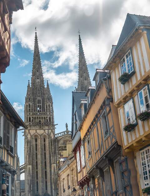Straße in Quimper, Frankreich mit Kathedrale Saint Corentin im Hintergrund | © Gettyimages.com/Wirestock