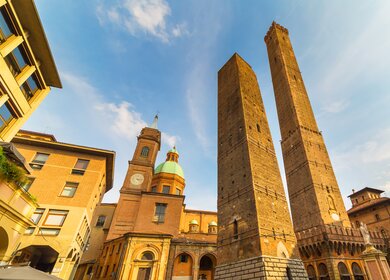 Torre Garisenda und Torre degli Asinelli von Bologna bei Sonnenschein | © Gettyimages.com/KellyISP