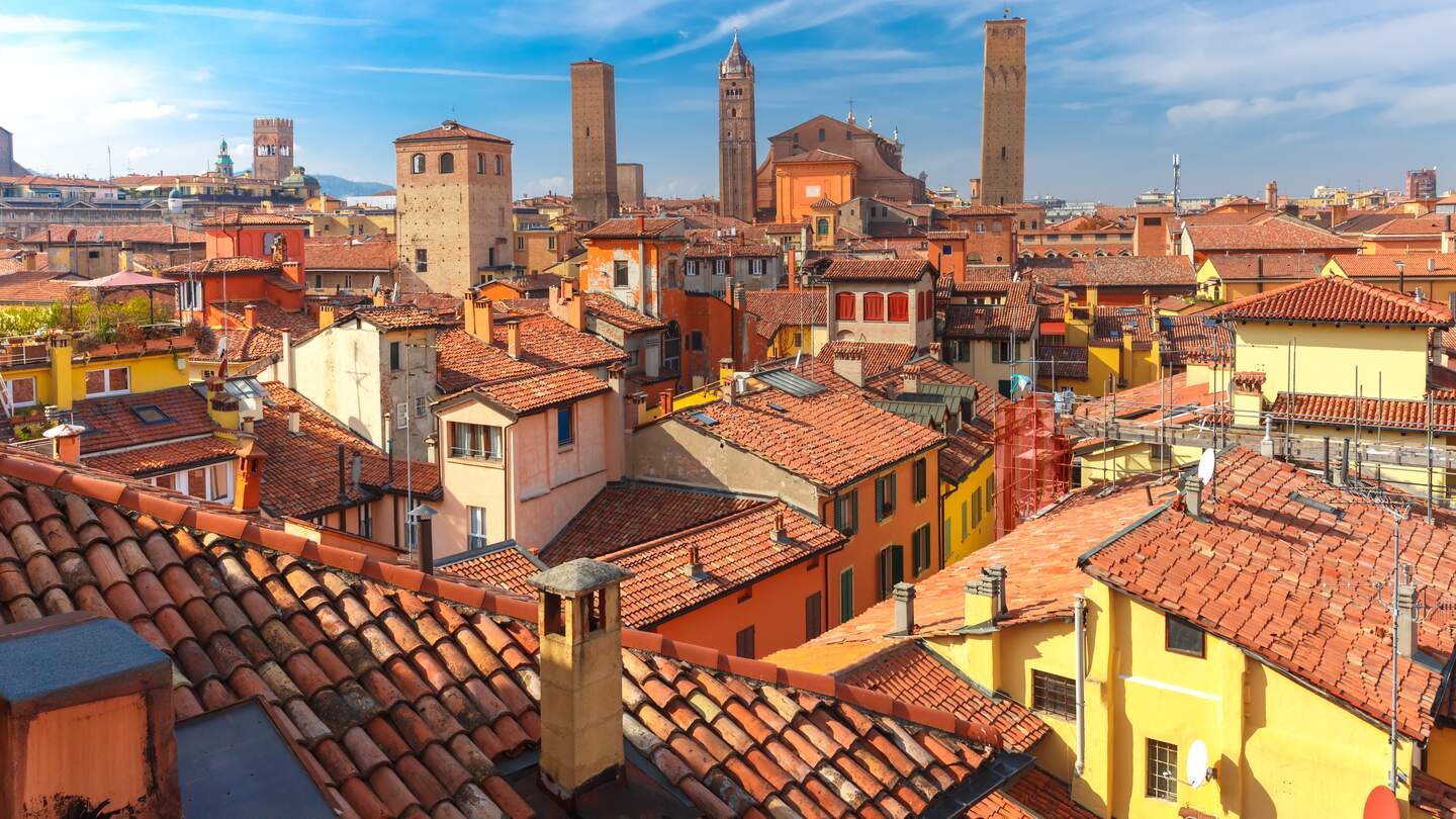 Luftaufnahme der Kathedrale von Bologna und der Türme, die ueber den Daechern der Altstadt in der mittelalterlichen Stadt Bologna am sonnigen Tag thronen | © Gettyimages.com/KavalenkavaVolha