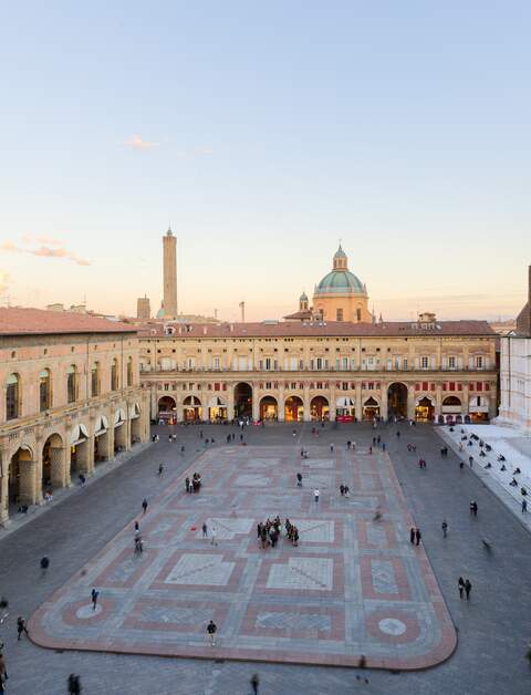 Touristen aus aller Welt für die Piazza Maggiore mit der basilika San Pietrino und der Torre dell’Arengo | © Gettyimages.com/minoandriani