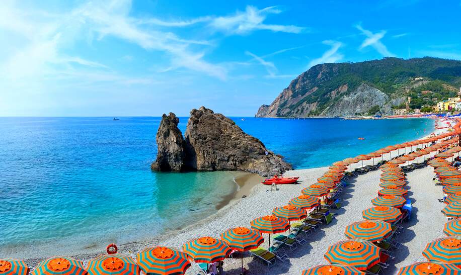 Blick auf bunte Sonnenschirme am Sandstrand in Monterosso, Cinque Terre, Italien, mit dem türkisblauem Meer im Hintergrund | © Gettyimages.com/jenifoto