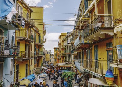 Eine malerische Straße im Stadtzentrum von Manarola, einem der Cinque Terre Dörfer, mit bunten Häusern, die die typischen mediterranen Farben widerspiegeln. | © Gettyimages.com/serts