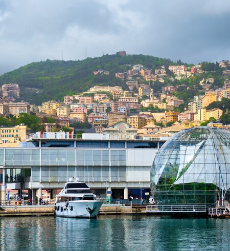 Der Alte Hafen (Porto Antico) in Genua, mit Yachten und Booten und dem größten Aquarium Europas im Vordergrund. Im Hintergrund sieht man die Stadt auf grünen Hügeln | © Gettyimmages.com/f9photos
