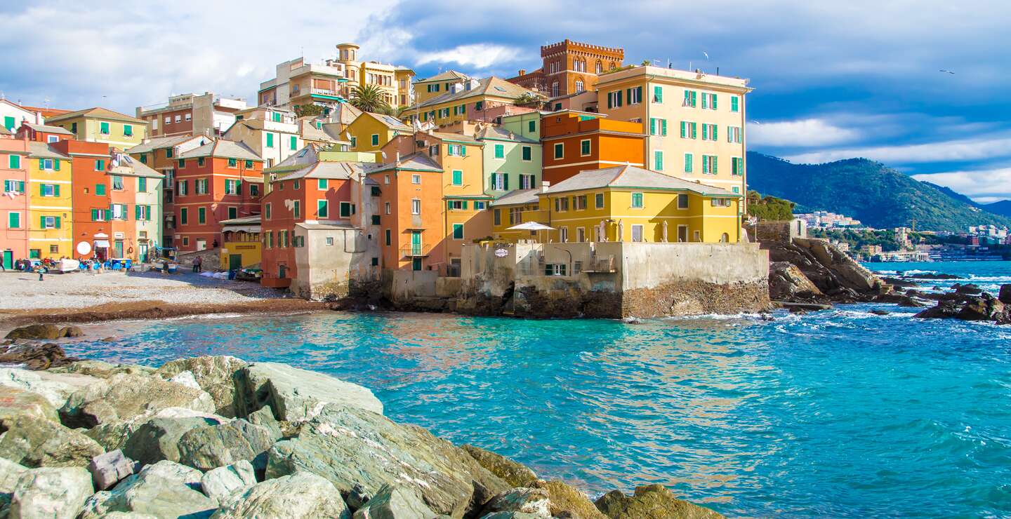 Boccadasse, das malerische Fischerdorf in Genua, Italien, mit einem kleinen Strand umgeben von bunten Häusern entlang der Küste. | © Gettyimmages.com/marcociannarel