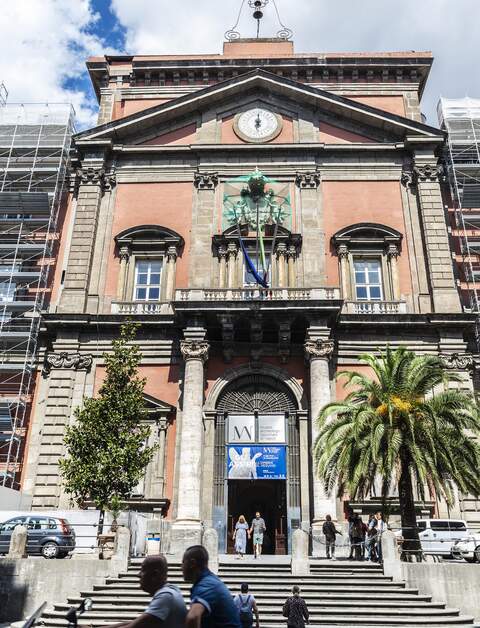 Blick auf den von zwei Säulen flankierten Eingang des Archäologisches Nationalmuseum von Neapel  | © gettyimages.com/Jordi de Rueda