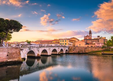 Blick auf die Altstadt von Rimini mit der Tiberiusbrücke, einer römischen Sehenswürdigkeit, bei Sonnenuntergang | © Gettyimages.com/alex_ugalek