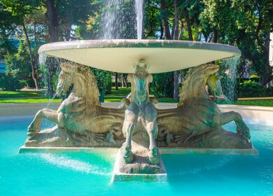 Springbrunnen der Vier Pferde Brunnen mit türkisfarbenem Wasser im Park Parco Federico Fellini mit grünen Bäumen im touristischen Stadtzentrum Rimini | © Gettyimages.com/Aliaksandr Antanovich