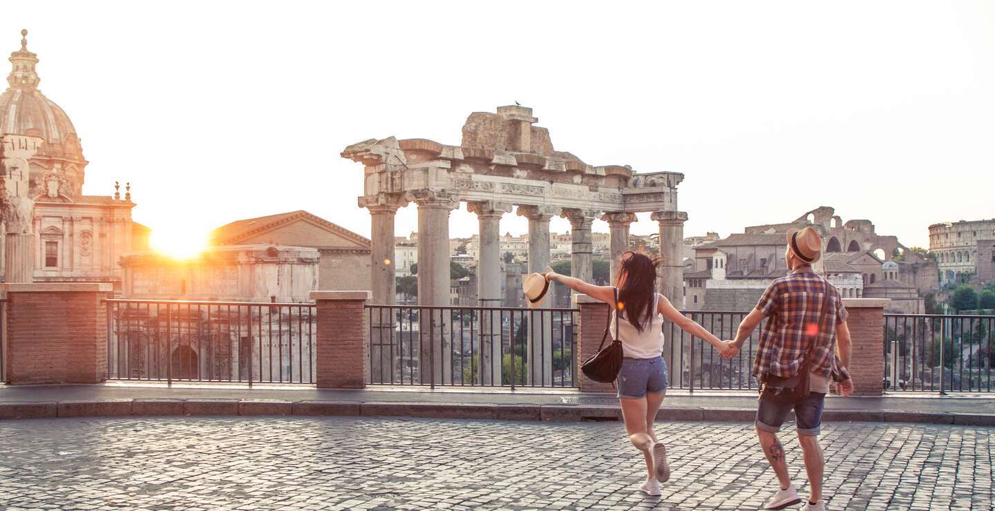 Junges Paar Touristen zu Fuss in Richtung Forum Bei Sonnenaufgang. Historisches kaiserliches Foro Romano in Rom, Italien aus Panoramensicht.  | © Gettyimages.com/tfilm