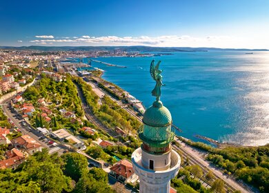 Atemberaubender Ausblick von oben auf Triest und das Adriatische Meer, mit dem Faro della Vittoria im Vordergrund | © Gettyimages.com/xbrchx