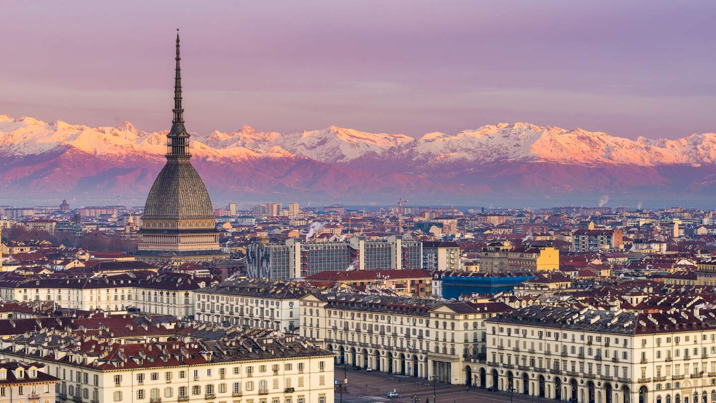 Blick auf die Mole Antonelliana und die Stadt Turin im Piemont, Italien, im stimmungsvollen Licht, mit den schneebedeckten Alpengipfeln im Hintergrund. | © GettyImages/Fabio Lammana
