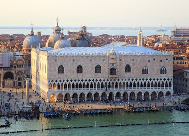 Der Dogenpalast am Markusplatz mit Passanten im Vordergrund in Venedig | © Gettyimages.com/ToolX