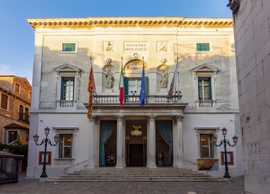 Frontalansicht auf das von der nachmittaglichen Sonne angestrahlte Phoenix Theater (Gran Teatro La Fenice) in Venedig, Italien | © Gettyimages.com/Vladislav Zolotov