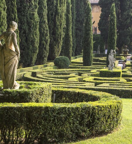 Italienischer Garten mit Statuen und gruenen Baeumen in Verona, Italien | © Gettyimages.com/violinconcertono3