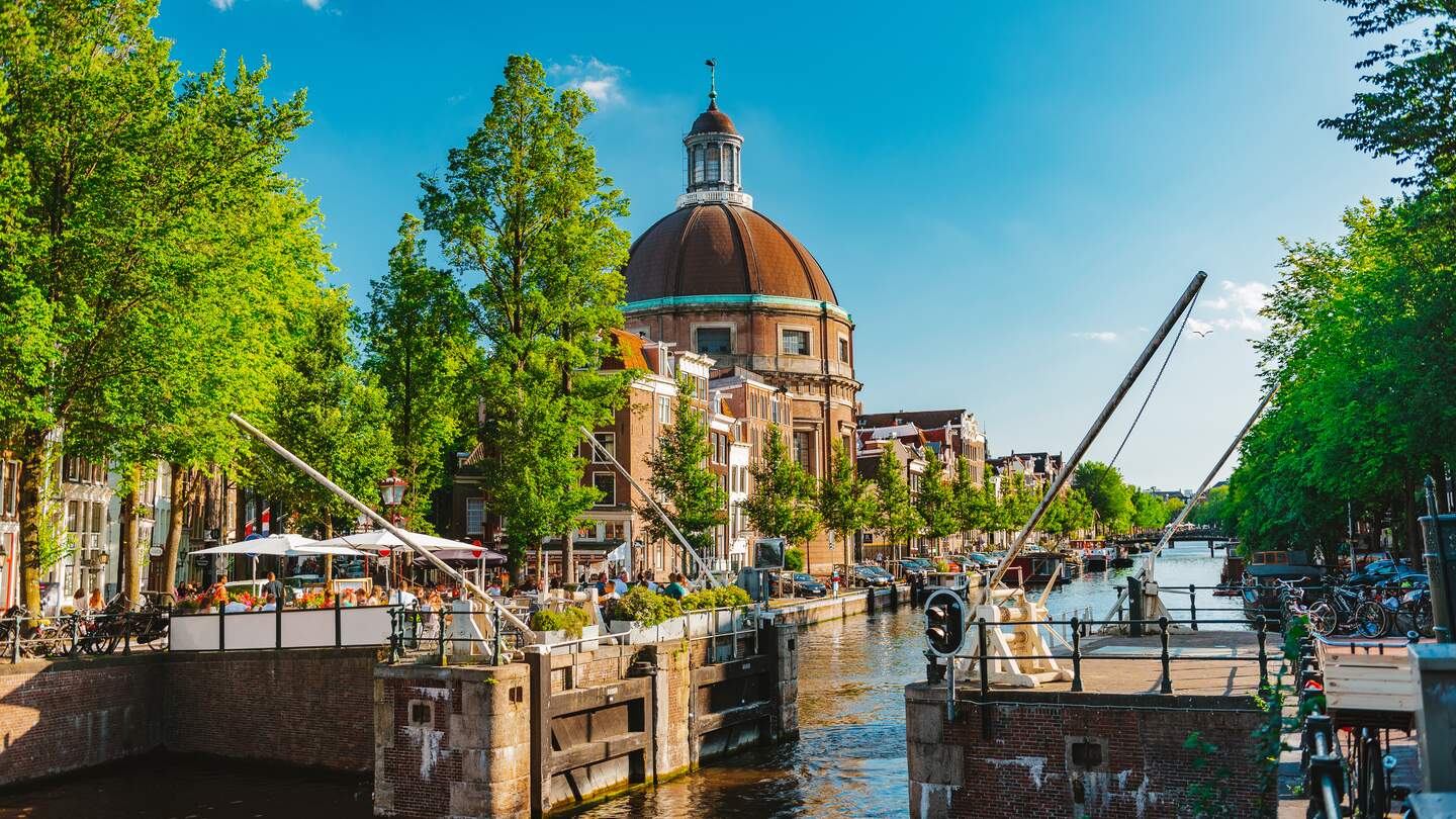 Grachtenschleuse mit belebtem Café und der klassizistisch barocken Ronde Lutherse Kerk im Hintergrund | © Gettyimages.com/Rocky89