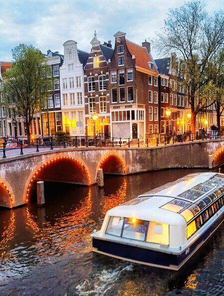 Abendliche Rundfahrt durch die beleuchteten Grachten in Amsterdam | © Gettyimages.com/Eloi_Omella