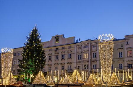 Beleuchtete Daecher der Huetten am Weihnachtsmarkt in Linz mit Weihnahctsbaum | © Gettyimages.com/Orietta Gaspari