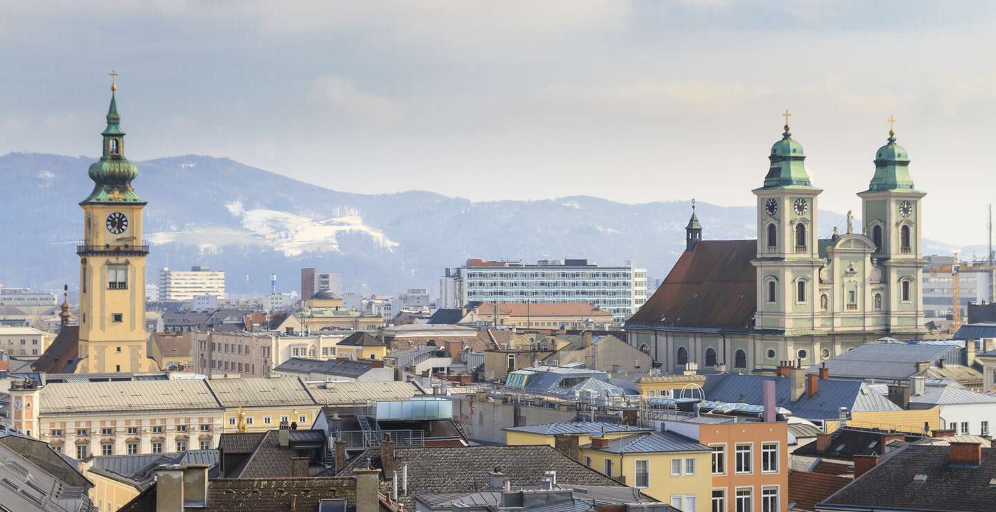 Blick ueber die Daecher der Altstadt von Linz mit Bergen im Hintergrund | © Gettyimages.com/Bertl123