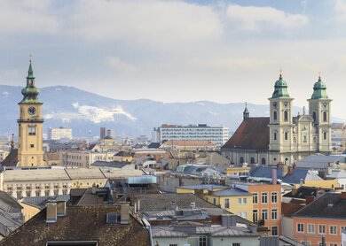 Blick ueber die Daecher der Altstadt von Linz mit Bergen im Hintergrund | © Gettyimages.com/Bertl123