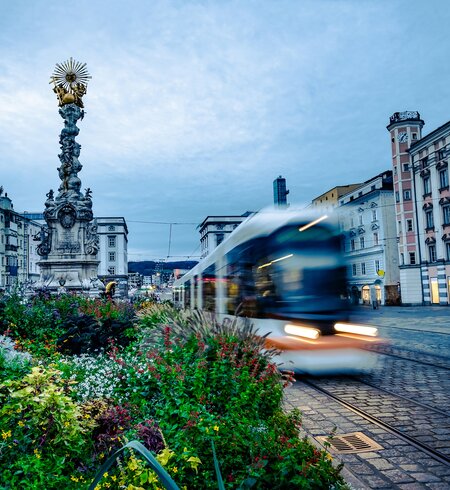 Dreifaltigkeitssaeule am Hauptplatz in Linz mit vorbeifahrender Bahn  | © Gettyimages.com/Zheka-Boss