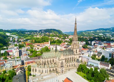 Blick von oben auf die Marienkirche in Linz mit wunderschoener Landschaft | © Gettyimages.com/saiko3p
