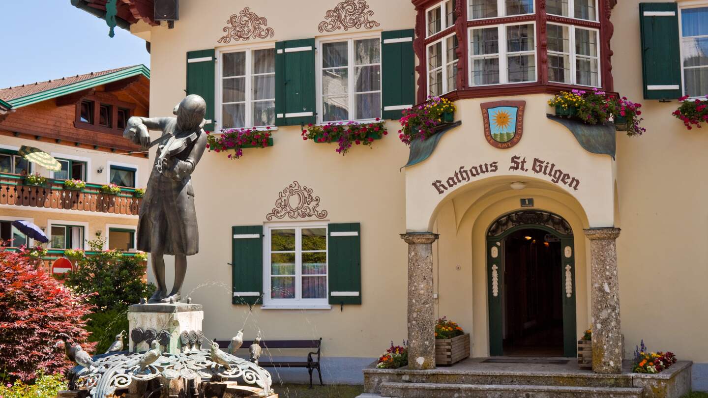 Statue des jungen Mozart und Rathaus am Mozartplatz in Salzburg | © Gettyimages.com/slowcentury
