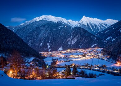 Mayrhofen im Zillertal während der Dämmerung: Schneebedeckte Landschaft und imposante Bergkulisse. | © Gettyimages.com/frahaus