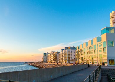 Turning Torso umgeben von Gebäuden und Meer im Sonnenlicht in Malmö in Schweden  | ©  Gettyimages.com/Wirestock
