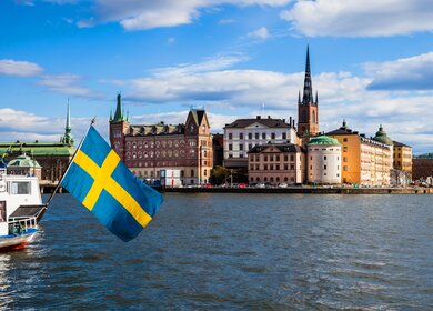 Stockholm, Schweden. Panorama der Altstadt und der Kirche an einem schönen Fruehlingstag mit Flagge | © Gettyimages.com/Leonardo Patrizi