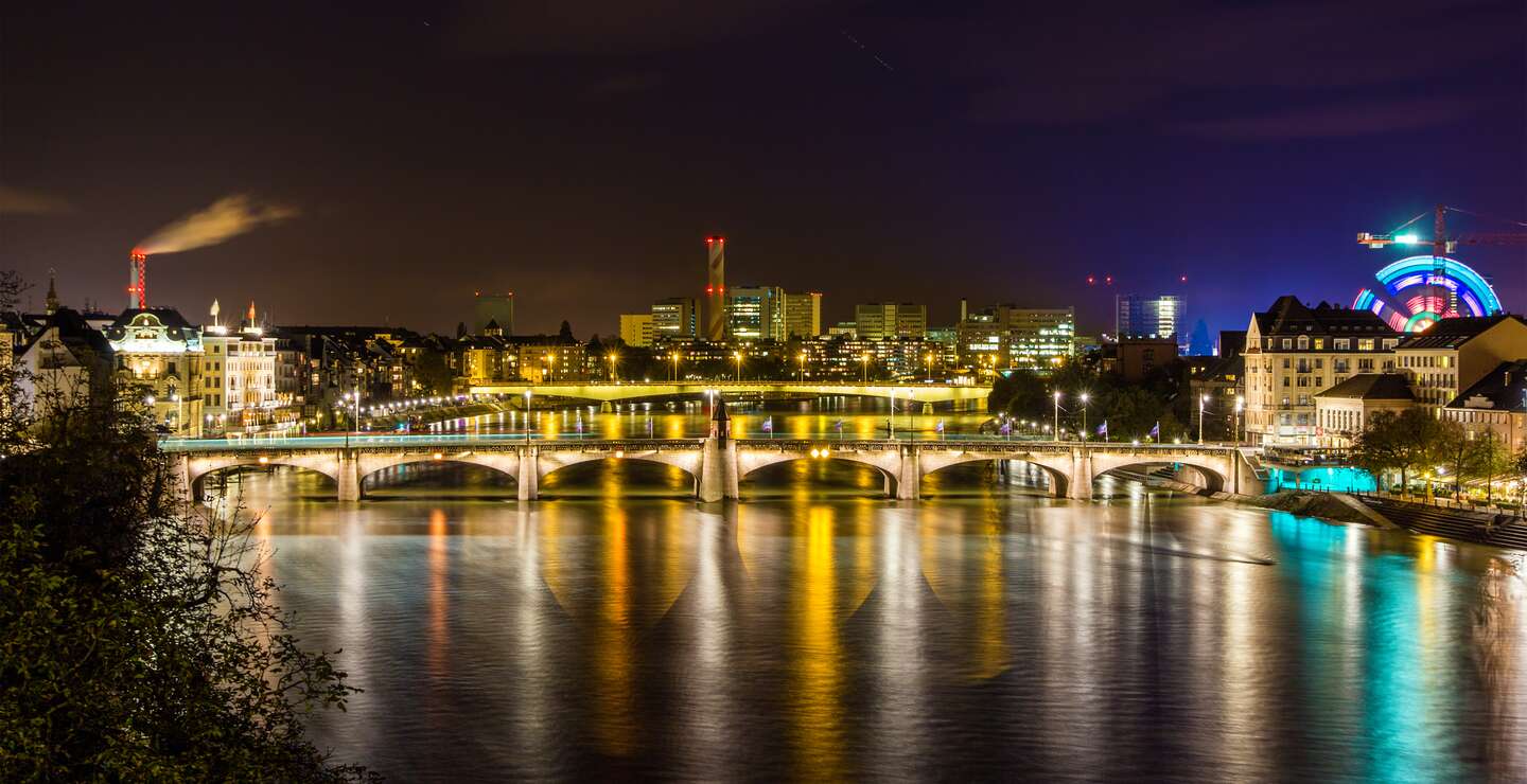 Das Rheinufer und die beleuchtete Stadt Basel bei Nacht | © Gettyimages.com/Leonid Andronov