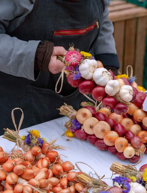 Zwiebelhaendler verkauft Zwiebeln und Knoblauch beim Berner Zwiebelmarkt in Bern, Schweiz | © Gettyimages.com/Irina Vishnyakova