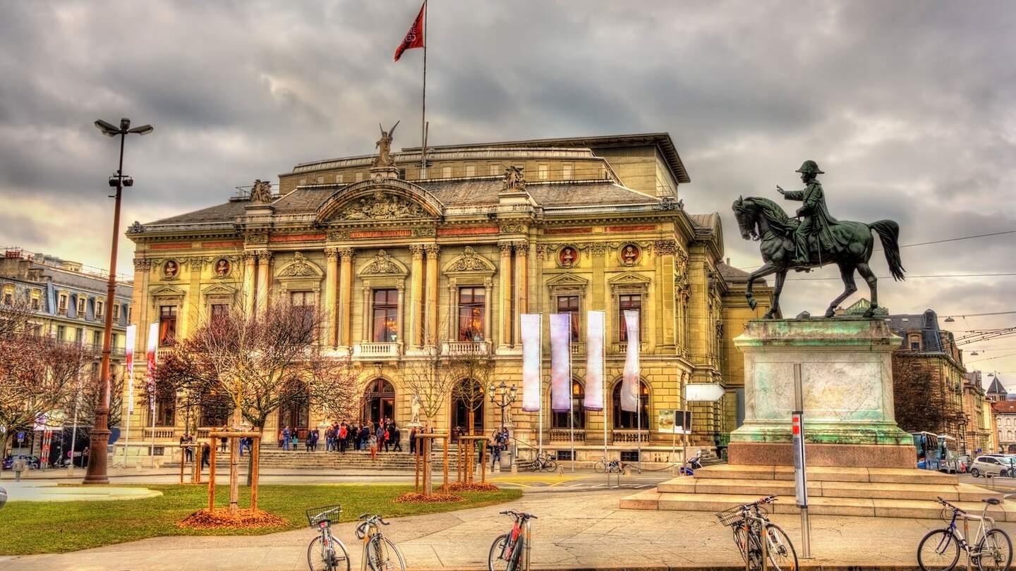 Grand Theatre de Geneve und Henri duplus Statue in Genf mit mbewölktem Himmel | © Gettyimages.com/Leonid Andronov