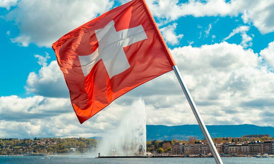 Schweizer Flagge ueber dem Genfer See vor Genf mit dem Fonfaene Jet d'Eau  | © Gettyimages.com/D-Keine