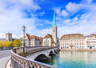  die Fraumuensterkirche in Zuerich mit ihrem markanten blauen Turm, die sich malerisch am Flussufer erhebt. | ©  Gettyimages.com/SCStock