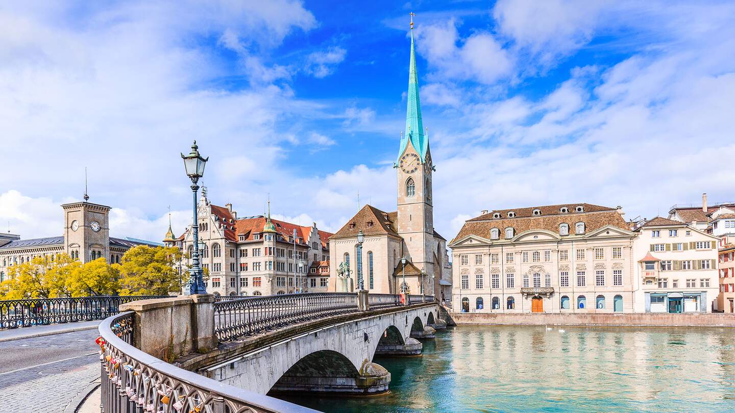  die Fraumuensterkirche in Zuerich mit ihrem markanten blauen Turm, die sich malerisch am Flussufer erhebt. | ©  Gettyimages.com/SCStock