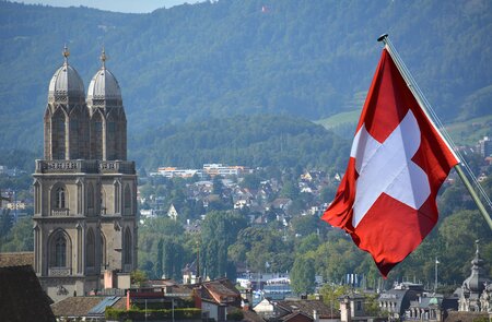 Schweizer Flagge vor der Grossmuensterkirche in Zuerich | ©  Gettyimages.com/lozanona