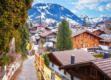 Idyllisches Alpendorf Gstaad in der Schweiz | © GettyImages.com/	xbrchx