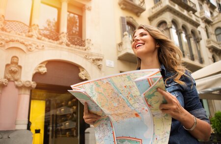 Frau mittleren Alters auf Reisen, mit Karte. Europa, Barcelona. | © gettyimages.com/svetikd